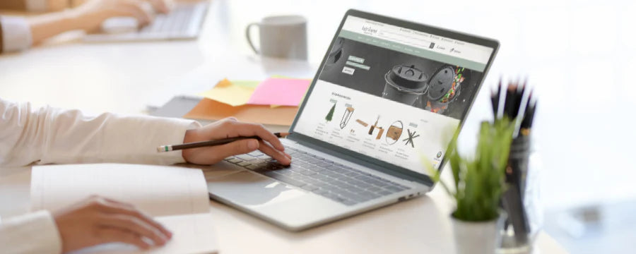 Person betrachtet den holz4home-Onlineshop auf einem Laptop in einem hellen Büro