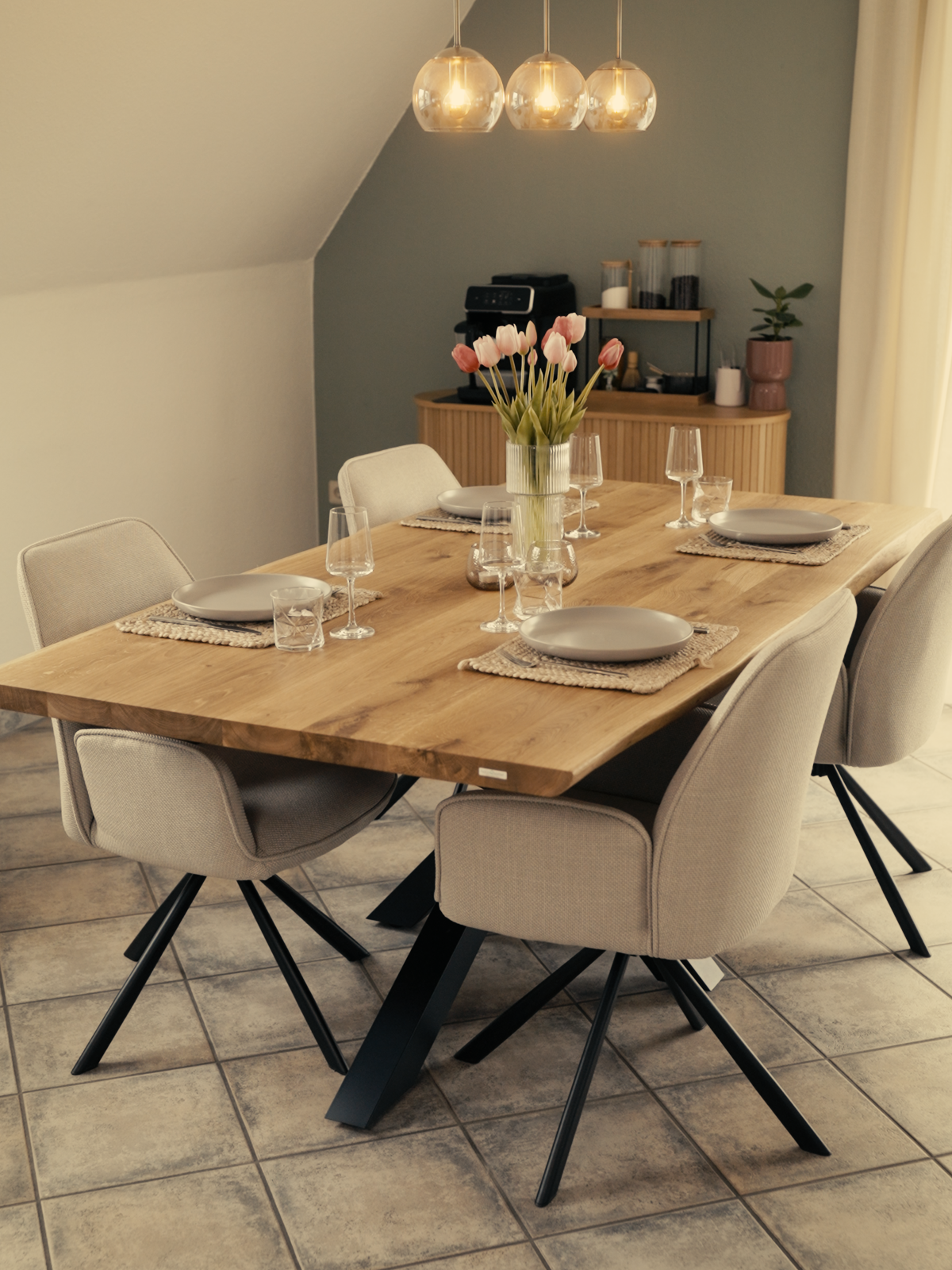 Eichentisch mit Baumkante im Esszimmer, gedeckt mit Geschirr und Tulpen, Spider-Gestell, beige Polsterstühle